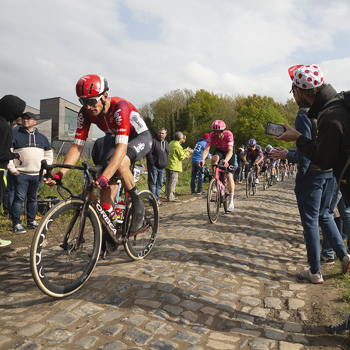 Paris Roubaix 2025 - Brent Van Moer of Lotto leads a group through a crowd lined sector