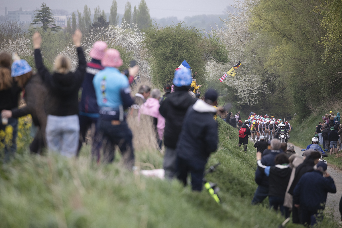 Paris Roubaix 2025 - Fans line the high banks at the side of the sector as they watch the peloton approach