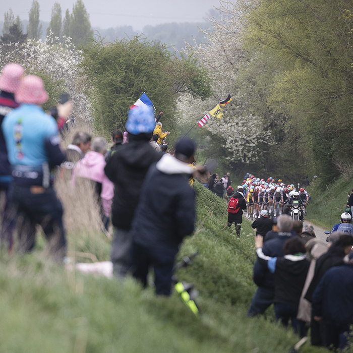 Paris Roubaix 2025 - Fans line the high banks at the side of the sector as they watch the peloton approach
