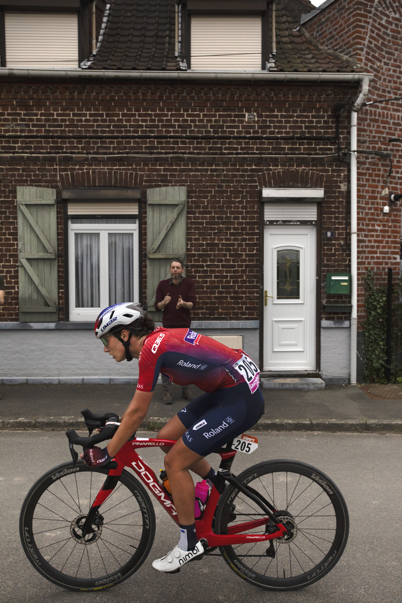 Paris Roubaix Femmes 2024 - Sylvie Swinkels of Roland passes a cottage as a fan applauds in Bourghelles