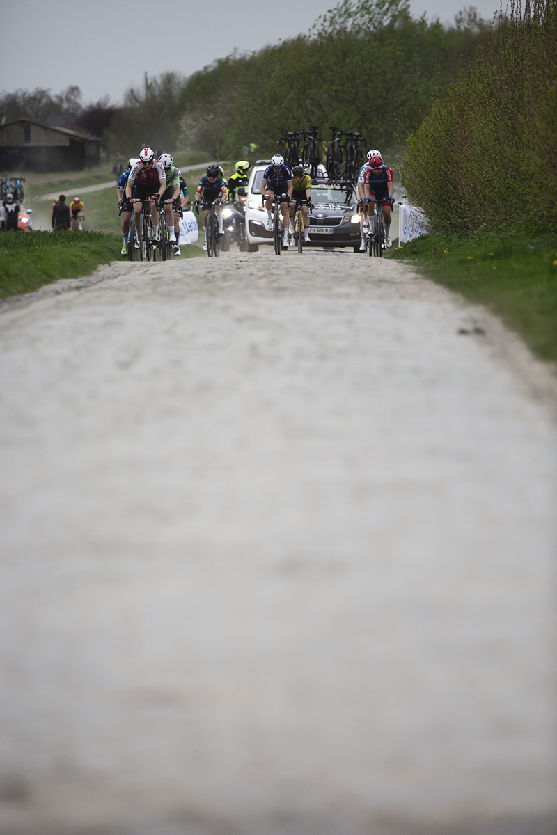 Paris Roubaix Femmes 2024 - With the cobbles of Cysoing à Bourghelles stretching out in front of them, a group of riders tackle the sector