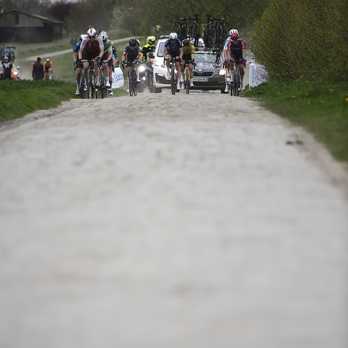Paris Roubaix Femmes 2024 - With the cobbles of Cysoing à Bourghelles stretching out in front of them, a group of riders tackle the sector