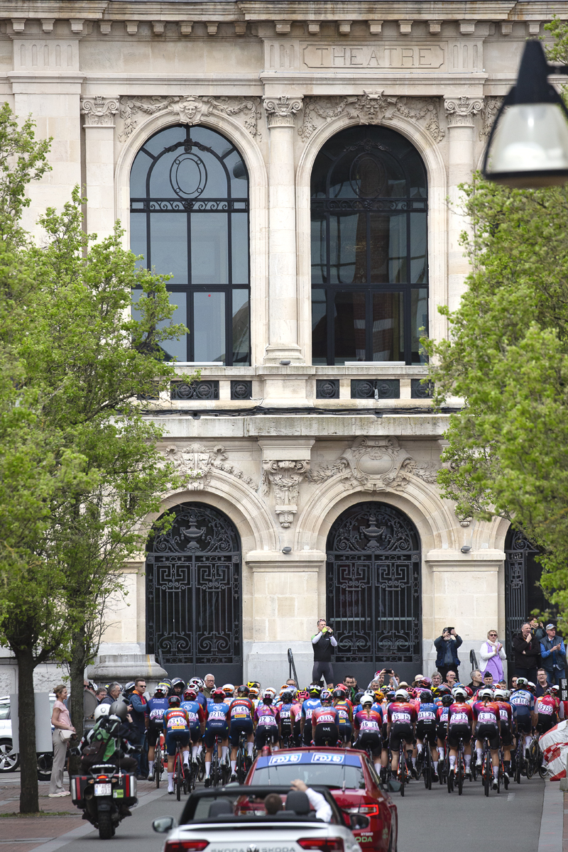 Paris Roubaix Femmes 2024 - The peloton from behind as it passes the Municipal Theater du Denain