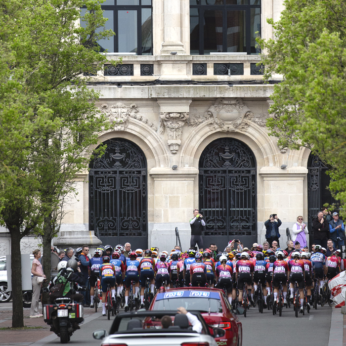 Paris Roubaix Femmes 2024 - The peloton from behind as it passes the Municipal Theater du Denain