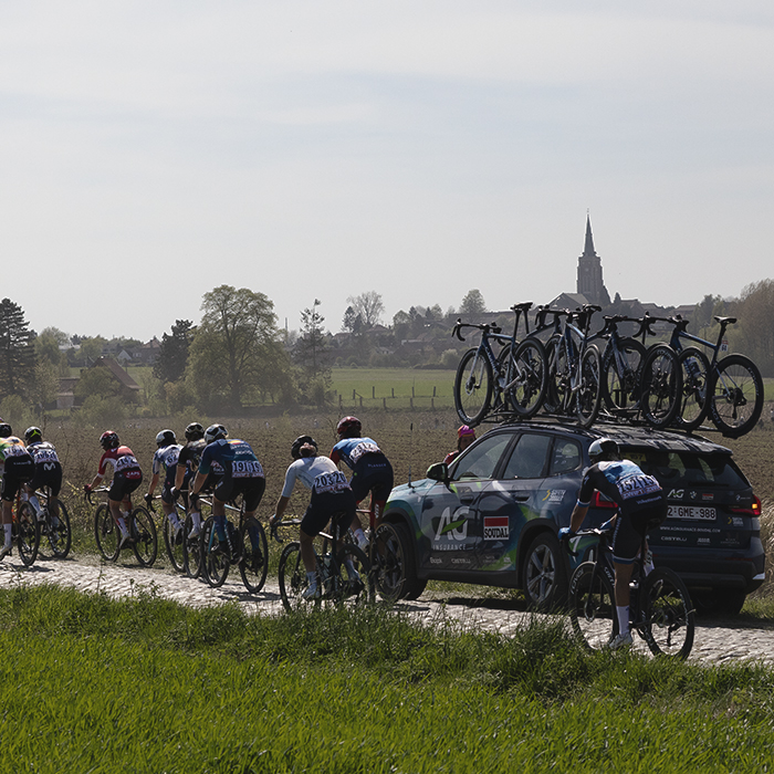 Paris Roubaix Femmes 2025 - Danish fans watch a group of riders pass with a church seen in the distance