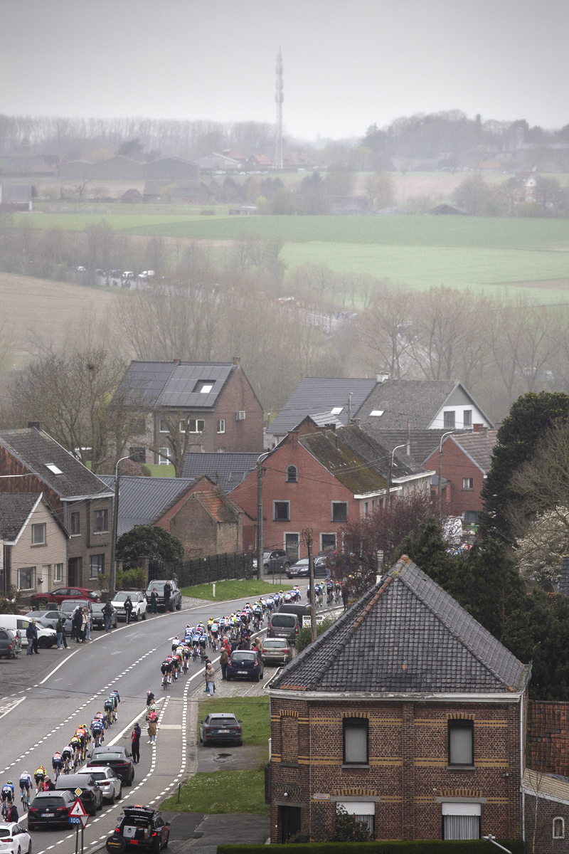 Ronde van Vlaanderen 2024 - The race seen from above as riders pass cars parked on the route in Zegelsem