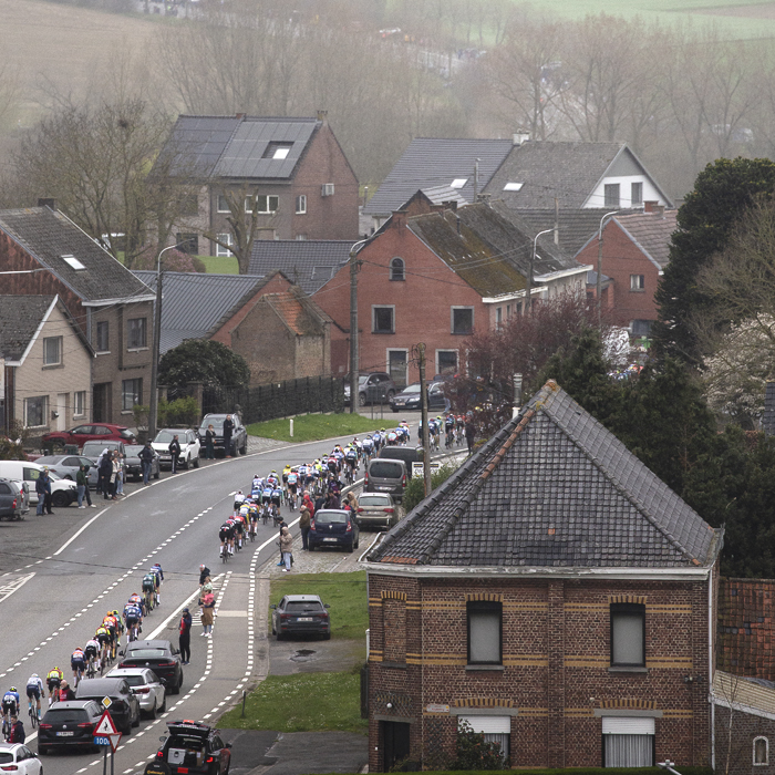 Ronde van Vlaanderen 2024 - The race seen from above as riders pass cars parked on the route in Zegelsem
