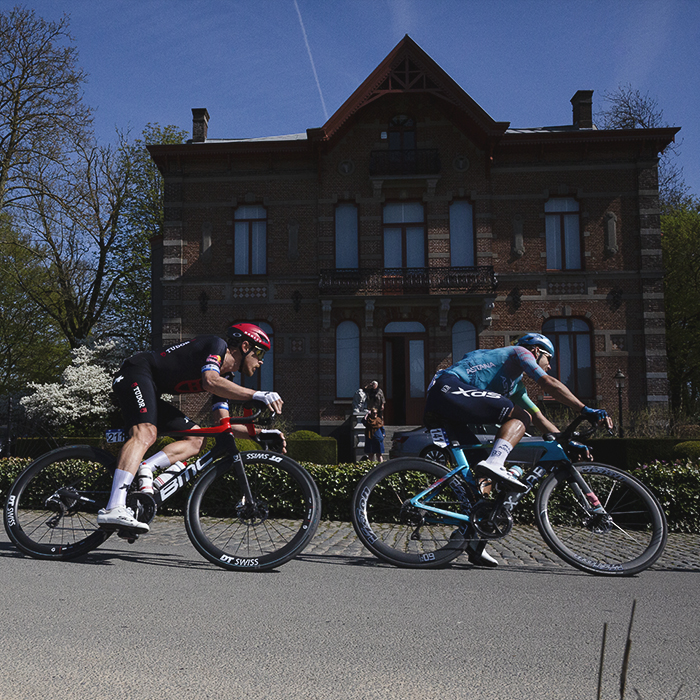 Ronde van Vlaanderen 2025 - Riders bank round a corner with Kasteel Grootveld in the background