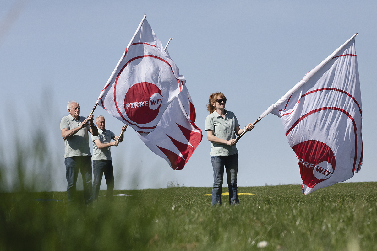 Ronde van Vlaanderen 2025 - Locals perform with flags before the race passes