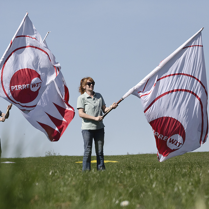 Ronde van Vlaanderen 2025 - Locals perform with flags before the race passes