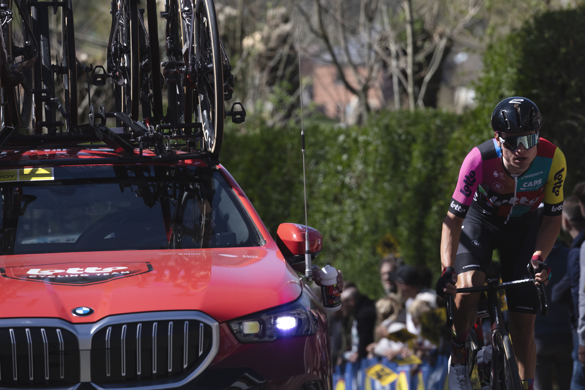 Ronde van Vlaanderen 2025 - Lennert Van Eetvelt climbs next to a team car in his special changed team kit