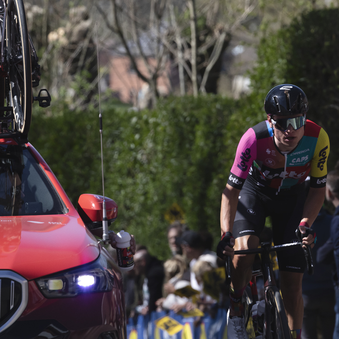 Ronde van Vlaanderen 2025 - Lennert Van Eetvelt climbs next to a team car in his special changed team kit