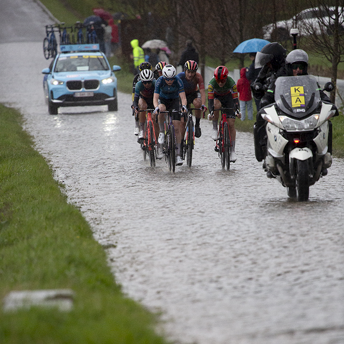 Ronde van Vlaanderen Vrouwen 2024 - Fans shelter under umbrellas as riders approach on Mariaborrestraat