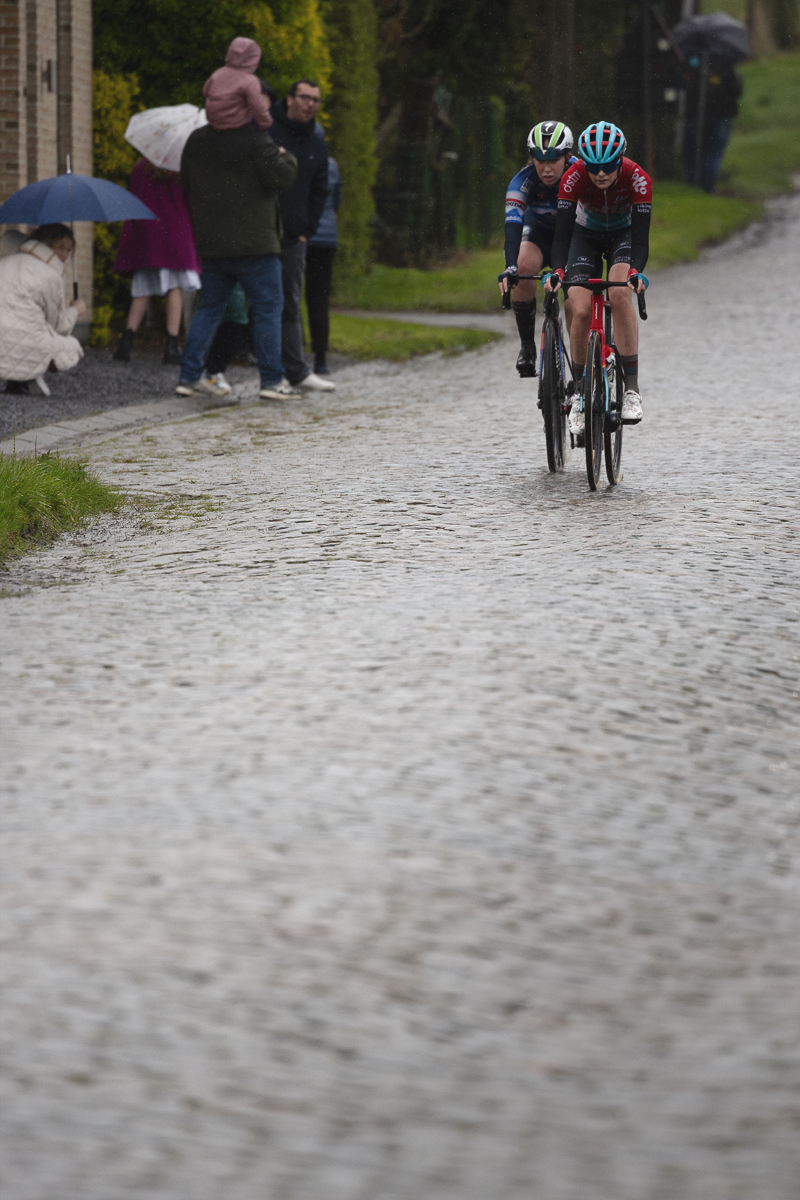 Ronde van Vlaanderen Vrouwen 2024 - Quinty van de Guchte & Maud Rijnbeek watched by fans under umbrellas on Mariaborrestraat