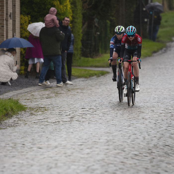 Ronde van Vlaanderen Vrouwen 2024 - Quinty van de Guchte & Maud Rijnbeek watched by fans under umbrellas on Mariaborrestraat