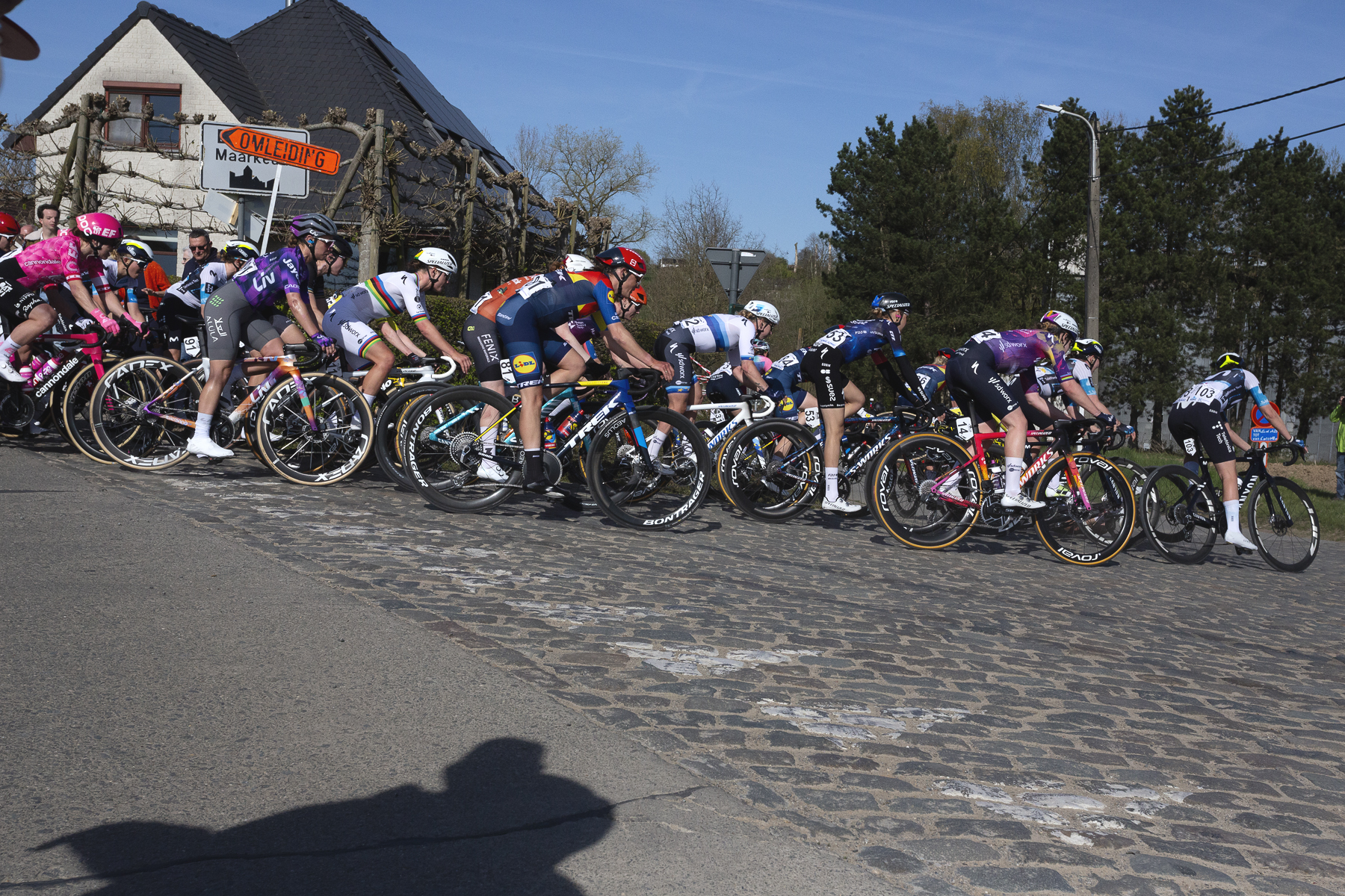 Ronde van Vlaanderen Vrouwen 2025 - Riders take a corner onto the cobbles in Maarkedal