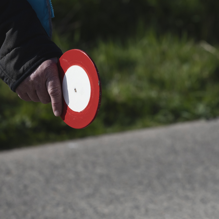 Ronde van Vlaanderen Vrouwen 2025 - A sign is held by one of the Signaalgevers