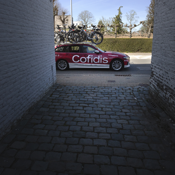 Ronde van Vlaanderen Vrouwen 2025 - A Cofidis team car is framed by an alleyway entrance