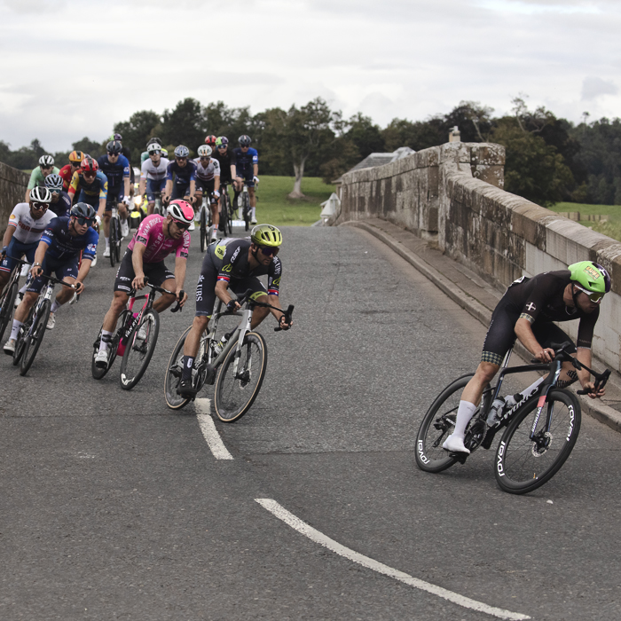 Tour of Britain 2024 - Riders cross Teviot Bridge before taking a tight corner on the way to Kelso