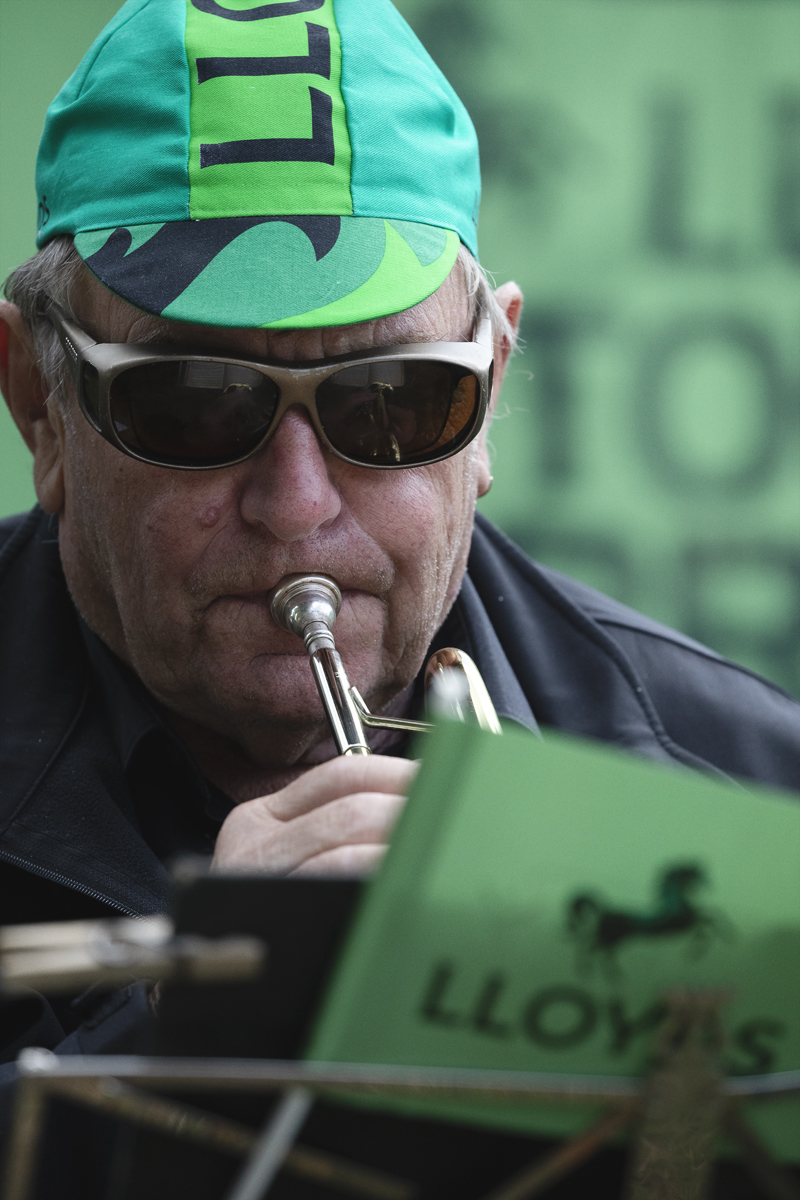 Tour of Britain 2025 - A member of a brass band in a Lloyds cap plays to the crowds
