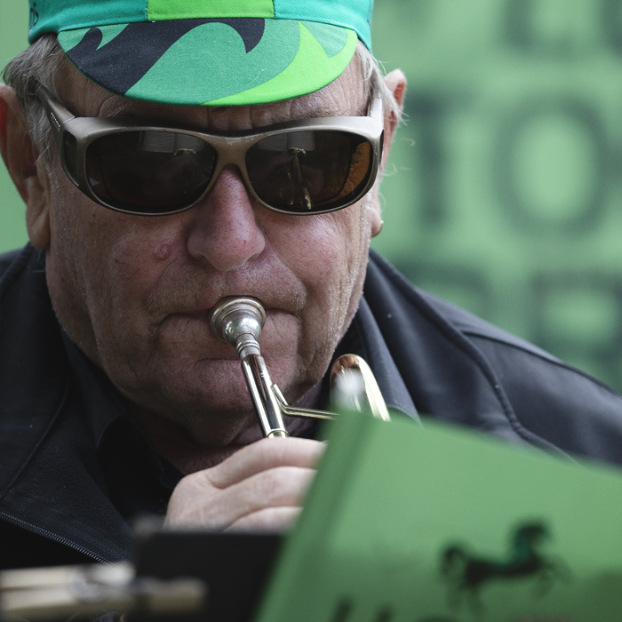 Tour of Britain 2025 - A member of a brass band in a Lloyds cap plays to the crowds
