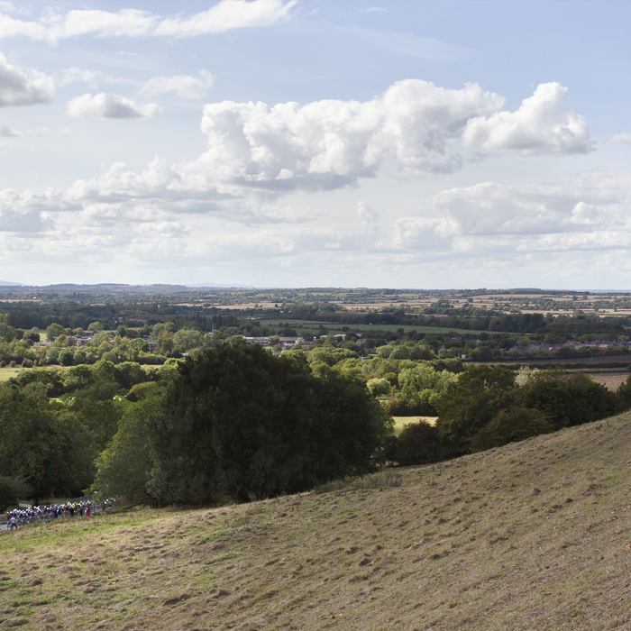 Tour of Britain 2025 - Riders seen in the distance fro the vantage point of a hill at Burton Dassett