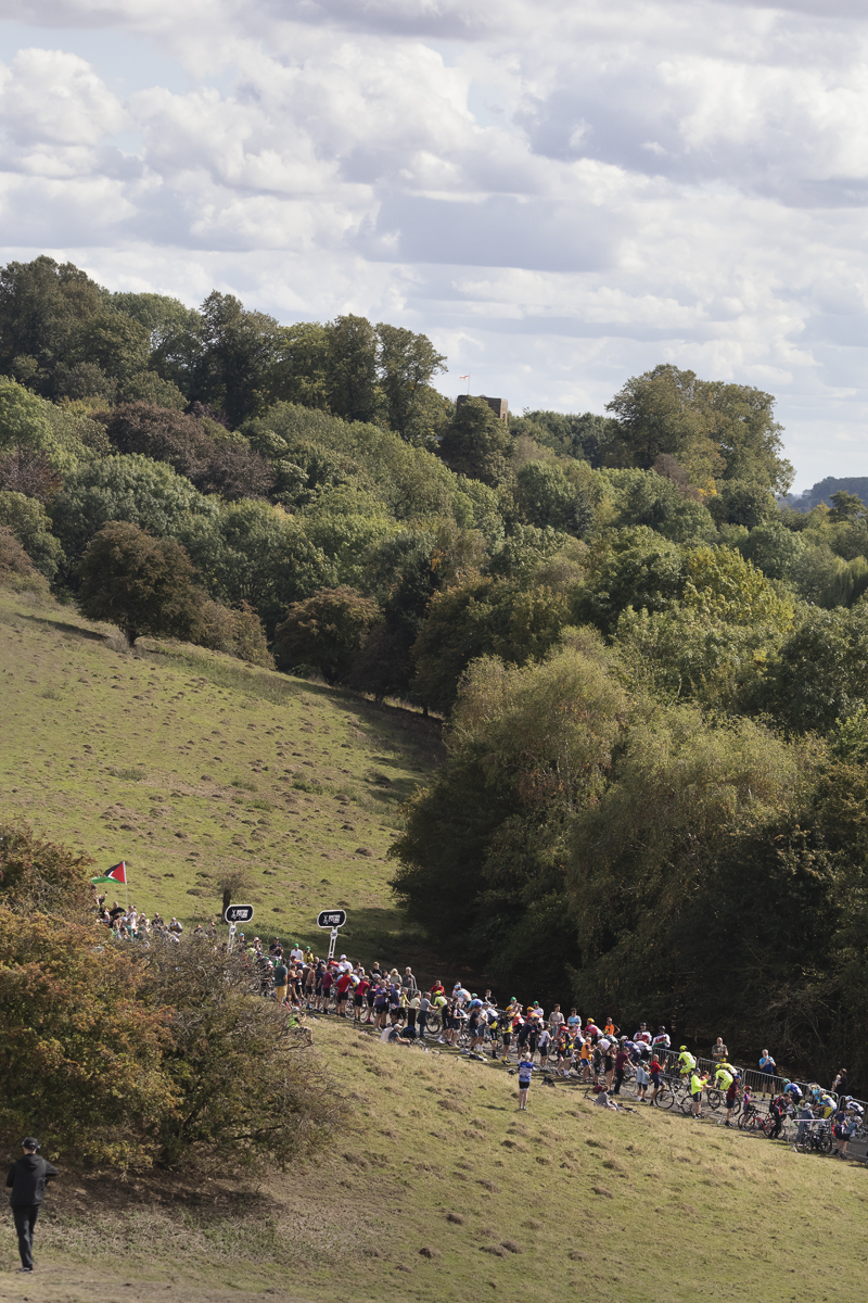 Tour of Britain 2025 - The peloton from a distance as it climbs the hill at Burton Dassett