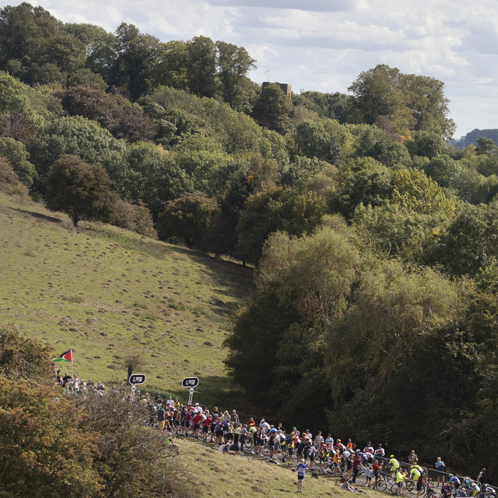 Tour of Britain 2025 - The peloton from a distance as it climbs the hill at Burton Dassett