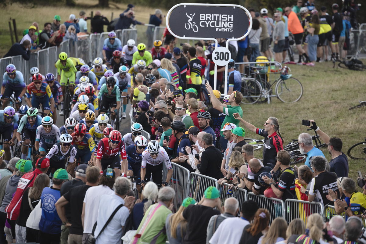 Tour of Britain 2025 - Crowds lean in to catch a view of the riders as they make the final push up the hill towards the finish at Burton Dassett