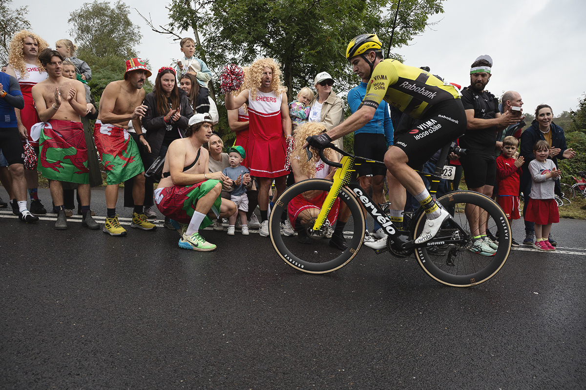 Tour of Britain 2025 - Edoardo Affini is encouraged onward by fans dressed as cheerleaders and wearing Welsh flags