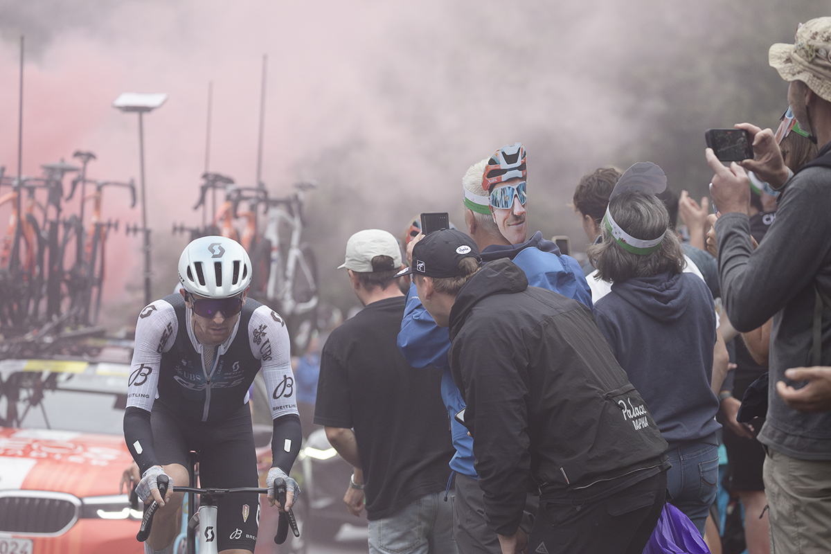 Tour of Britain 2025 - Mark Donovan is cheered on by fans as the red smoke from a flare can be seen in the background