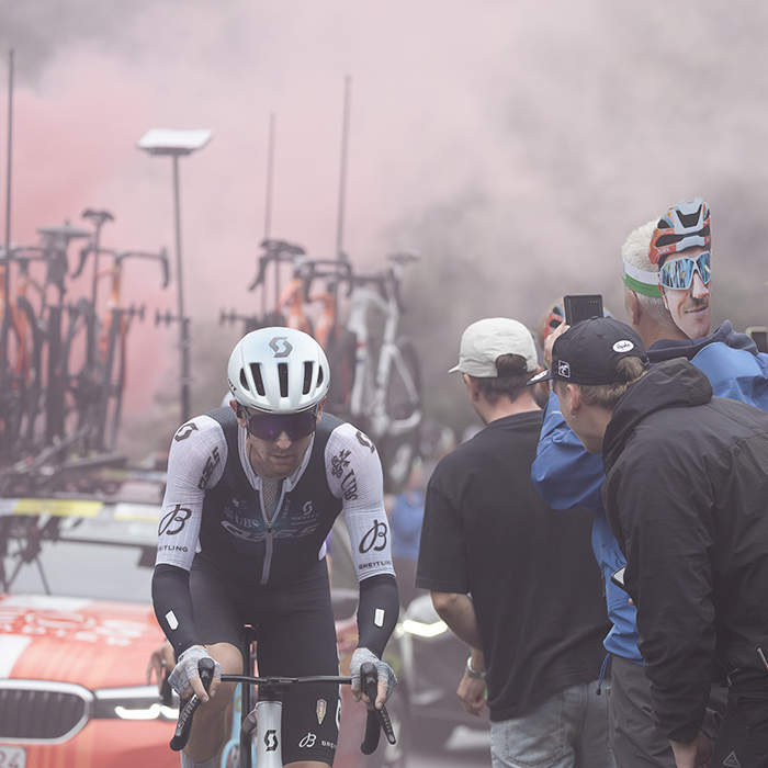 Tour of Britain 2025 - Mark Donovan is cheered on by fans as the red smoke from a flare can be seen in the background