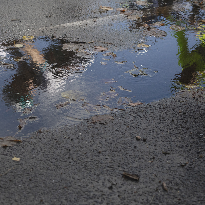Tour of Britain 2025 - The reflection of a rider in a puddle after heavy rainfall earlier in the day