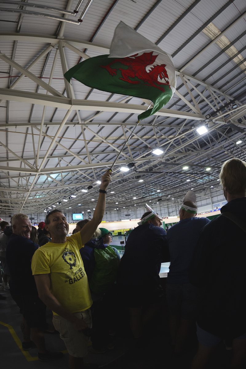 Tour of Britain 2025 - A fan wearing a T-Shirt with a picture of Geraint Thomas and the slogan Le Prince De Galles waves a Welsh flag in the velodrome