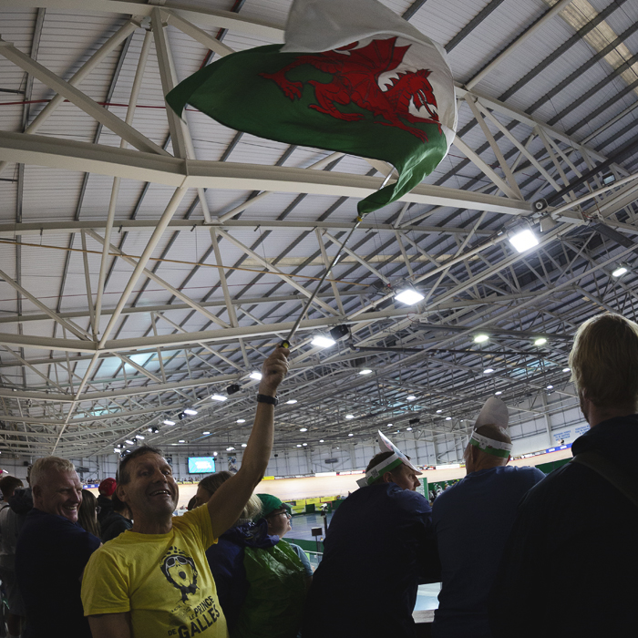 Tour of Britain 2025 - A fan wearing a T-Shirt with a picture of Geraint Thomas and the slogan Le Prince De Galles waves a Welsh flag in the velodrome