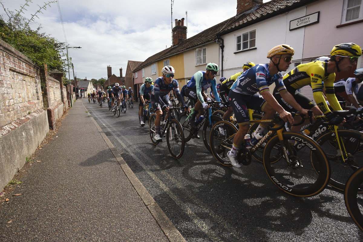 Tour of Britain 2025 - The peloton passed pastel coloured cottages in Saxmundham