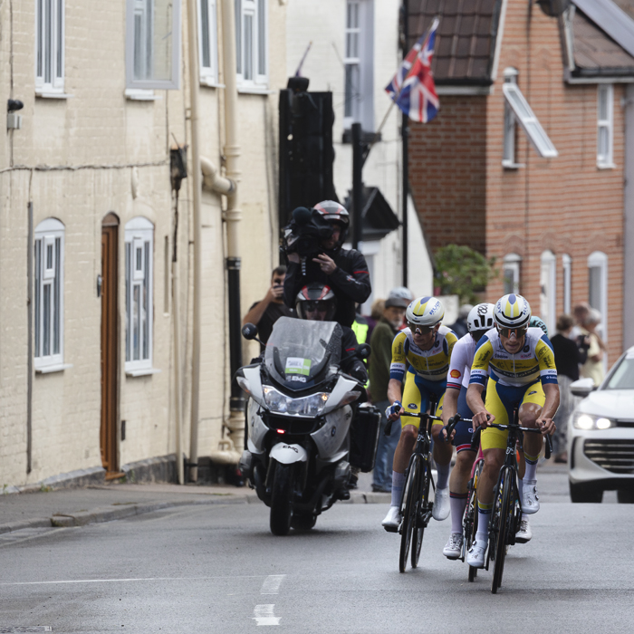 Tour of Britain 2025 - The breakaway lead by Milan Lanhove & Victor Vercouillie ride through Saxmundham, a Union flag seen behind them