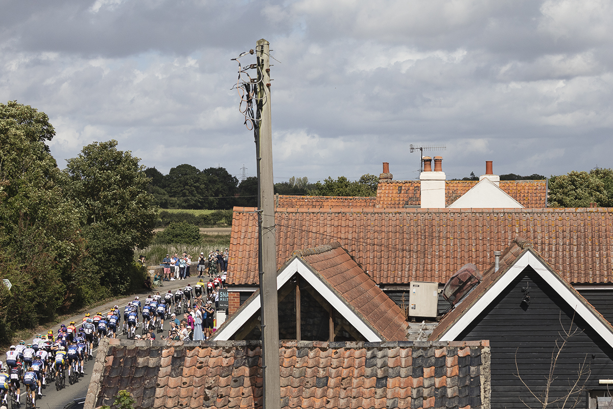 Tour of Britain 2025 - The peloton seen across the rooftops at Snape Maltings