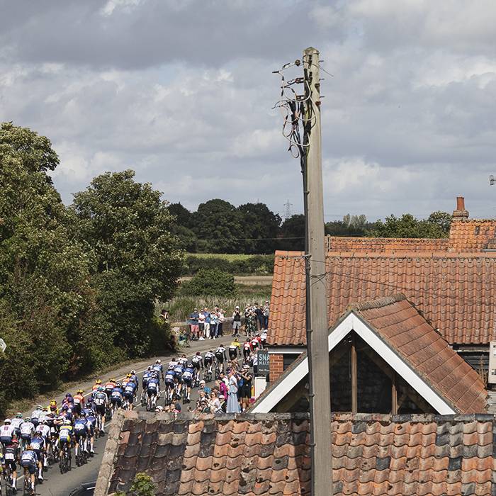 Tour of Britain 2025 - The peloton seen across the rooftops at Snape Maltings