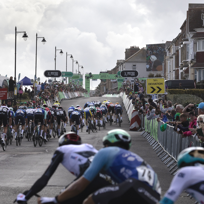 Tour of Britain 2025 - The peloton rounds the corner onto the finish straight on Southwold seafront