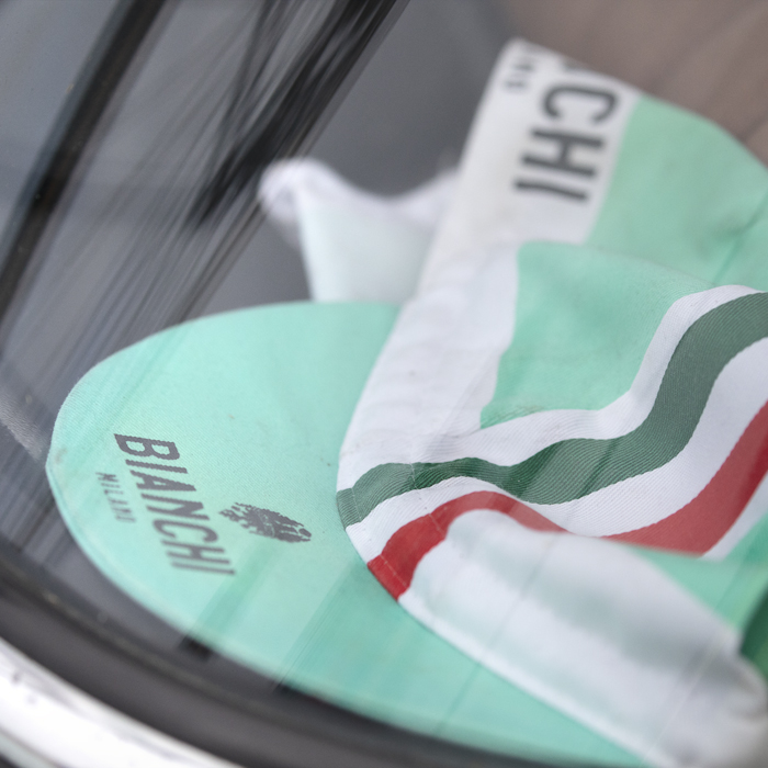 Tour of Britain 2025 - A Bianchi hat seen through the window of an Alfa-Romeo