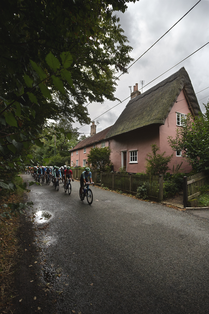 Tour of Britain 2025 - Riders pass a pink thatched cottage at Thornham Magna