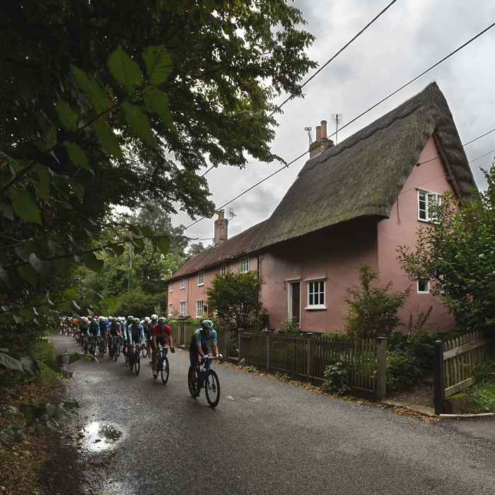 Tour of Britain 2025 - Riders pass a pink thatched cottage at Thornham Magna