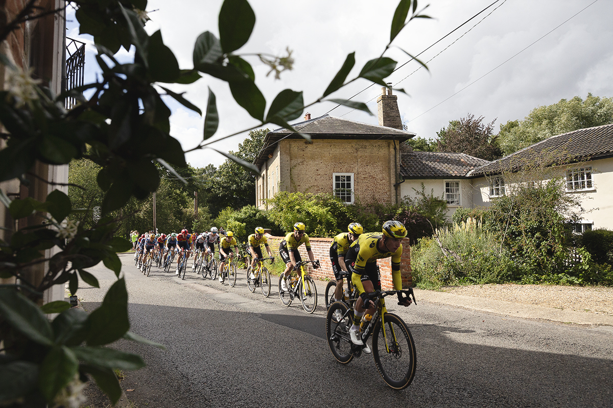 Tour of Britain 2025 - The peloton passes in front of a grand house in Walpole