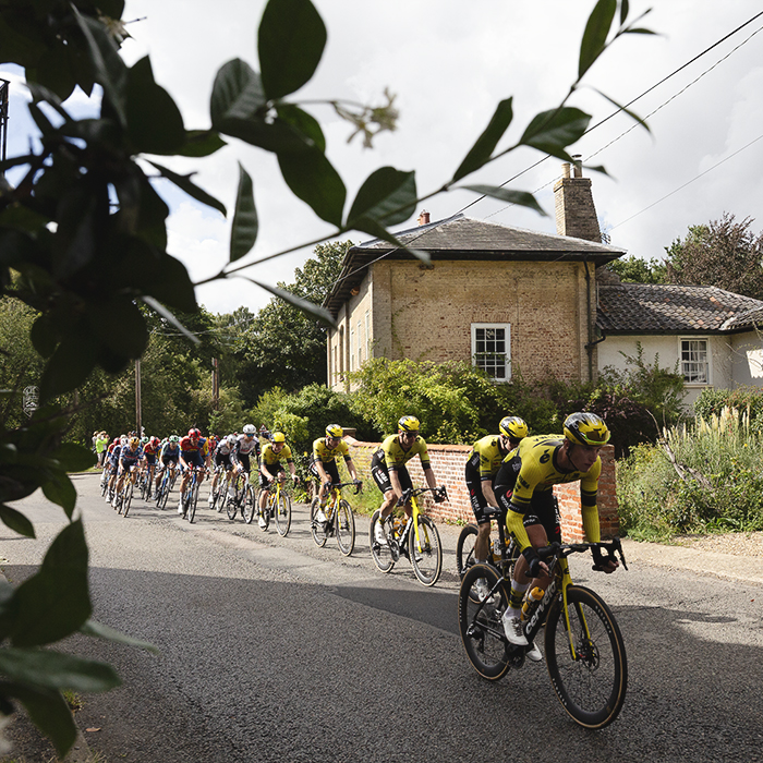 Tour of Britain 2025 - The peloton passes in front of a grand house in Walpole