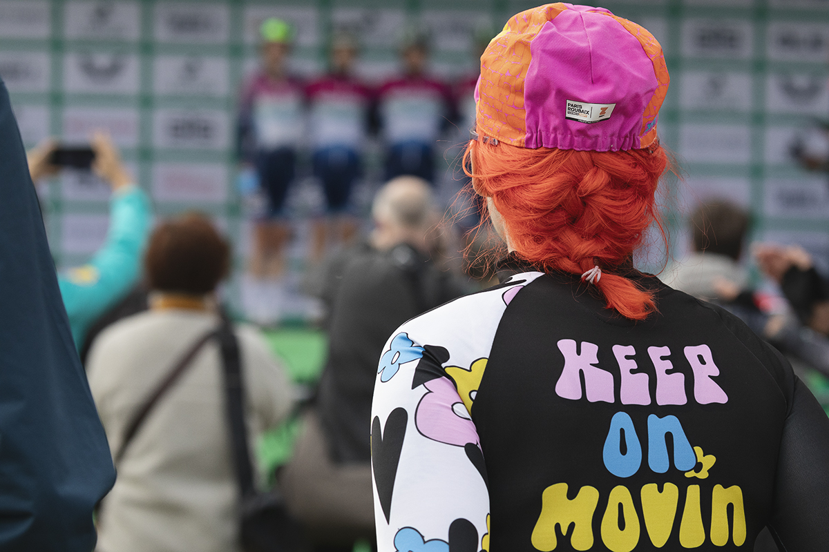 Tour of Britain Women’s 2025 - Stage 4 - A fan with bright orange hair and a top that reads Keep On Movin’ watches the presentation of teams before the stage in Glasgow