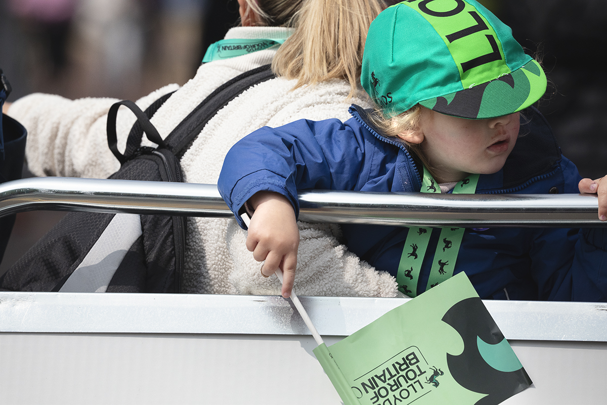 Tour of Britain Women’s 2025 - Stage 4 - A young fan sports a Lloyds branded flag and hat at the end of the stage