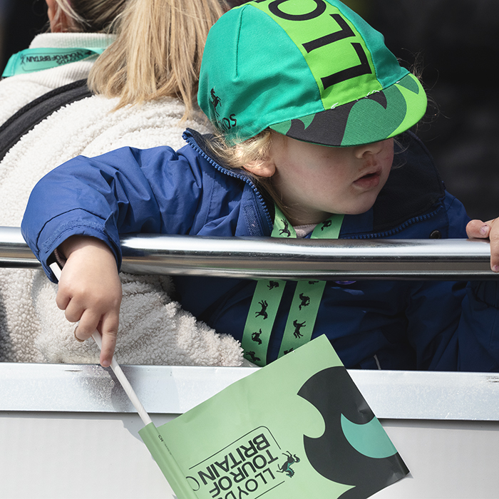 Tour of Britain Women’s 2025 - Stage 4 - A young fan sports a Lloyds branded flag and hat at the end of the stage