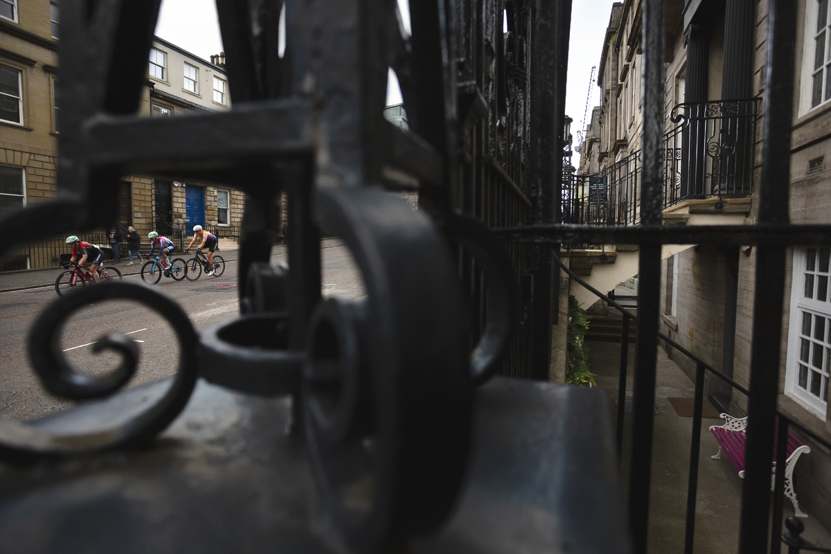 Tour of Britain Women’s 2025 - Stage 4 - Riders are framed in the iron railings of a building on St Vincent Street