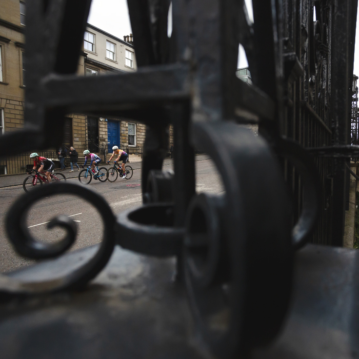 Tour of Britain Women’s 2025 - Stage 4 - Riders are framed in the iron railings of a building on St Vincent Street